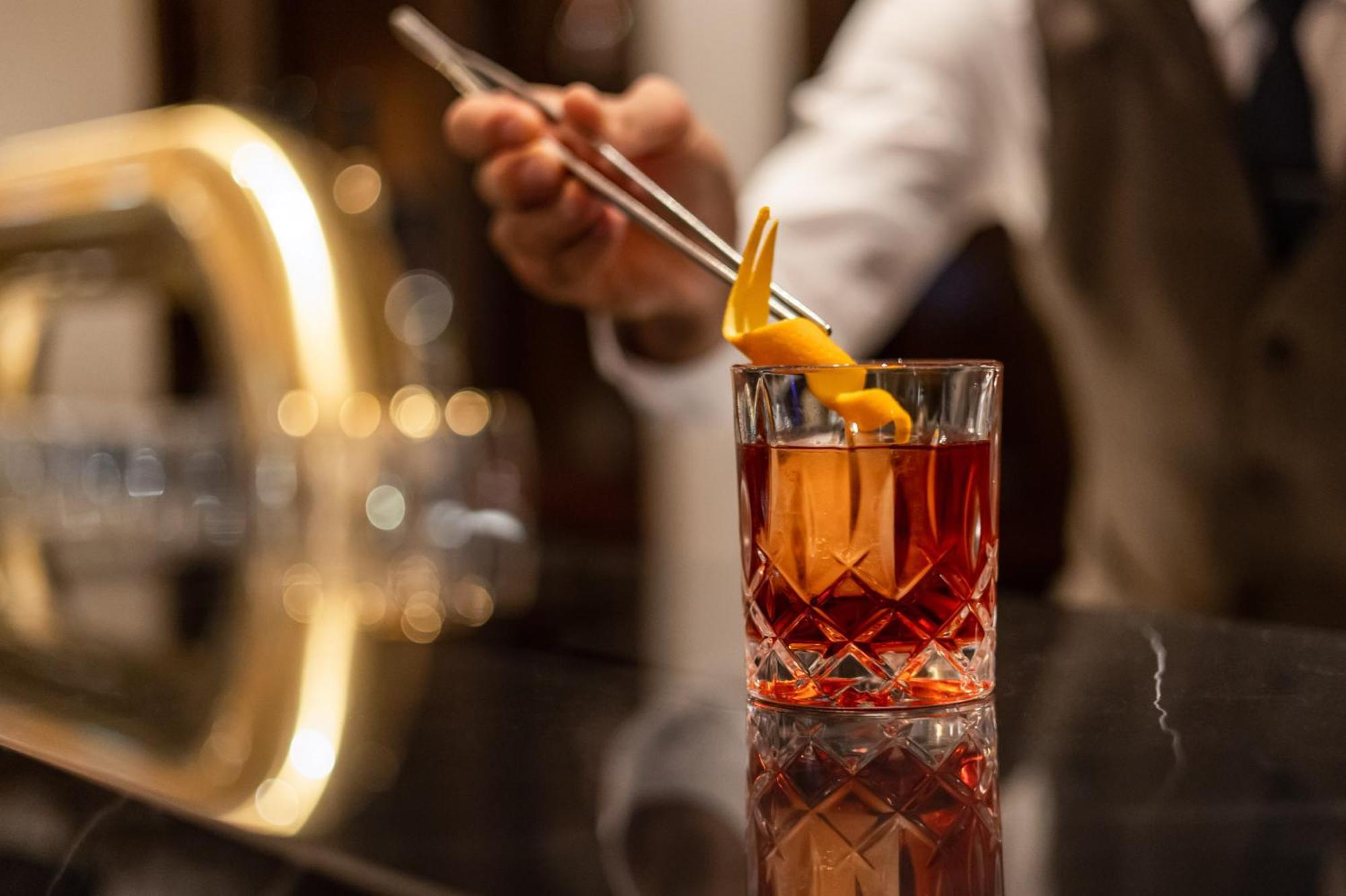 柏林洲际酒店 外观 照片 A bartender adding a lemon twist to a cocktail